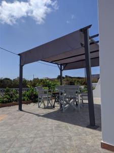 a picnic table and chairs under a canopy at Chrysiis House 2 in Analipsi