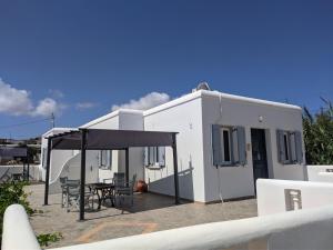 a white house with a patio with a table and chairs at Chrysiis House 2 in Maltezana