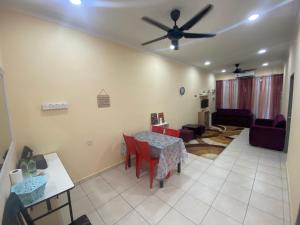uma sala de estar com uma mesa e uma ventoinha de tecto em Homestay Cikgu Muaz em Kuala Kangsar