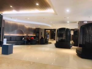 a lobby with people sitting on couches in a building at Mall of Asia Condotel Pasay Philippines in Manila