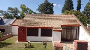 una pequeña casa roja y blanca con garaje en LA CASA DE RUMI en Villa Rumipal