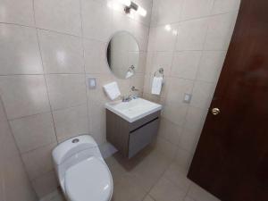 a bathroom with a toilet and a sink and a mirror at Point City Hotel in Guasave