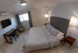 Dormitorio con cama, escritorio y TV en Point City Hotel, en Guasave