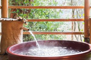 uma grande banheira de cobre com uma fonte de água em Momijiya Annex em Quioto