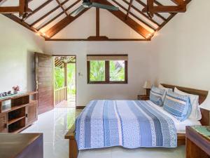 a bedroom with a bed and a wooden ceiling at Rumah Sunyi in Gili Trawangan