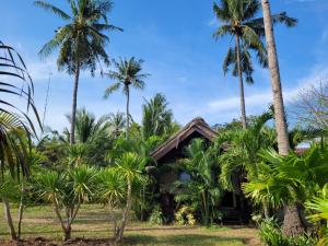 a house in the middle of palm trees at Rumah Sunyi in Gili Trawangan