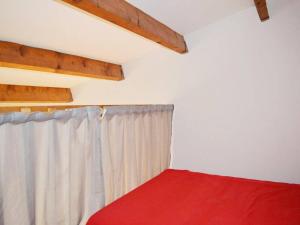 1 dormitorio con cama roja y cortina en Maison Narbonne, 1 pièce, 4 personnes - FR-1-229B-565, en Narbona