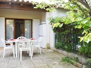 una mesa blanca y sillas en un patio en Maison Narbonne, 1 pièce, 4 personnes - FR-1-229B-565, en Narbona