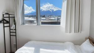 1 dormitorio con ventana y vistas a una montaña nevada en Megu fuji 2021 - Vacation STAY 74537v en Fujiyoshida