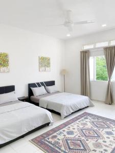 two beds in a white room with a rug at Kuala Terengganu Newly Renovated Nenda Beach House in Kuala Terengganu +17 photos