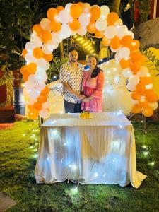 a man and a woman standing under a arch with balloons at VIP GARDEN RESORT in Varkala