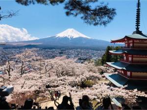 un gruppo di persone che guarda una montagna innevata di Megu fuji 2021 - Vacation STAY 74533v a Fujiyoshida