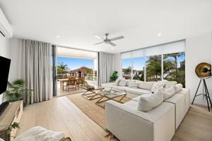 uma sala de estar com um sofá branco e uma grande janela em Luxury Alex Beach Home em Alexandra Headland
