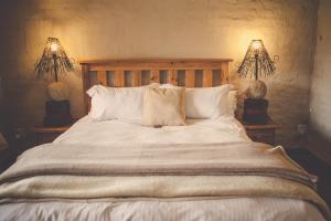 una camera da letto con un grande letto bianco con due lampade di Grincourt B&B- with No Load shedding a Polokwane