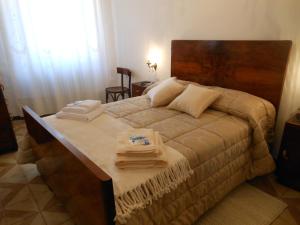 Serra deʼ ContiにあるB&B Le Stanze del Chiostroのベッドルーム1室(大型ベッド1台、タオル付)