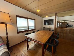 a dining room with a wooden table and chairs at NORD 3 自然豊かな家 - Manji Village - in Iwamizawa
