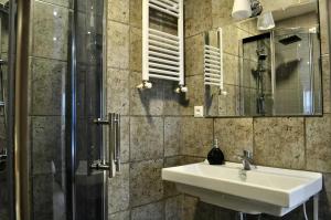 ein Bad mit einem Waschbecken und einer Dusche in der Unterkunft Panorama 360° Hotel in Tbilisi City