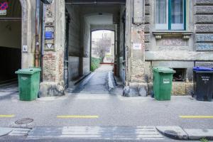 een steegje met twee groene vuilnisbakken in een gebouw bij Apartment G37 in Zagreb