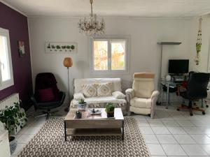 a living room with a couch and a table at La maison parisienne & jardin in Argenteuil