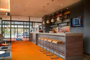 a restaurant with a bar with orange carpet at Campanile Leipzig Halle Airport in Leipzig