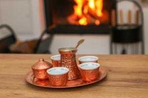 una bandeja de tazas de té y jarras en una mesa con chimenea en Brko 8 - Lazy Skiing Retreat en Jahorina