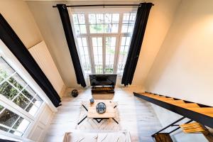 ein Wohnzimmer im Dachgeschoss mit einem großen Fenster in der Unterkunft Le Château Senard, Studio cosy 23 m2 au calme proche gare - 3 min in Rouen