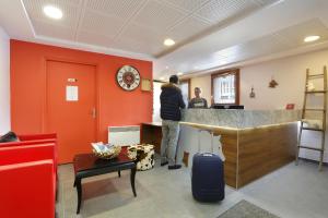 a man standing at a bar in a waiting room at Vacancéole - Au Coeur des Ours in Les Deux Alpes