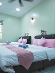 two beds in a room with pink and white at Octopus House Langkawi Easy Shop Easy Play in Kuah