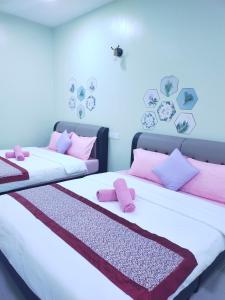 two beds in a room with pink pillows on them at Octopus House Langkawi Easy Shop Easy Play in Kuah