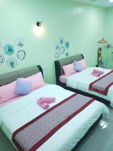 2 Betten in einem Zimmer mit rosa und lila Kissen in der Unterkunft Octopus House Langkawi Easy Shop Easy Play in Kuah