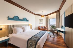 a hotel room with a bed and a desk at Welcomhotel by ITC Hotels, Devee Grand Bay, Visakhapatnam in Visakhapatnam