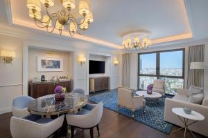 uma sala de estar com mesa e cadeiras e uma sala de estar em The Ritz-Carlton, Amman em Amã
