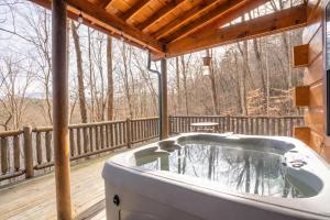 a bath tub on a porch with a deck at Moonshine Ridge Cabin with Hot Tub and Fire Pit in Pigeon Forge