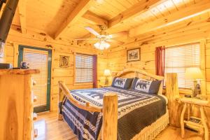 a bedroom with a bed in a log cabin at Moonshine Ridge Cabin with Hot Tub and Fire Pit in Pigeon Forge