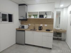 uma cozinha com armários brancos e um lavatório em La Cabaña de Eco Verde em San Rafael