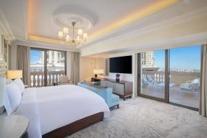 1 dormitorio con 1 cama blanca grande y balcón en The Ritz-Carlton, Amman en Amán