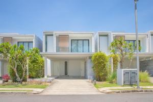 een wit huis met een oprit en bomen bij The Point Villa Da Nang in Da Nang