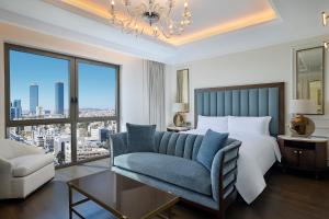 a bedroom with a bed and a couch and a window at The Ritz-Carlton, Amman in Amman