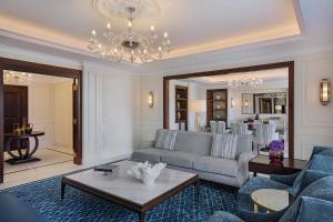 a living room with a couch and a chandelier at The Ritz-Carlton, Amman in Amman