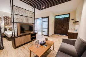a living room with a couch and a tv at Woda Villa & Spa in Sengkuang