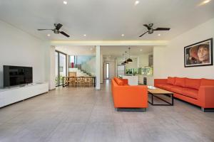 een woonkamer met een oranje bank en een tv bij The Point Villa Da Nang in Da Nang