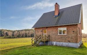 uma casa de tijolos com uma escada de madeira ao lado de um campo em Lovely Home In Bullaren With Wifi em Bullaren