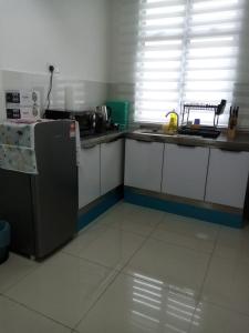 a kitchen with a counter and a refrigerator at Madinatus Syifa Homestay in Kota Tinggi