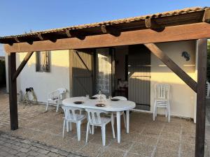 biały stół i krzesła na patio w obiekcie Maison avec Cour, Piscine Sécurisée, Climatisation, 3 Chambres, Proche Plage, 8 Personnes - FR-1-701-33 w mieście Vendres