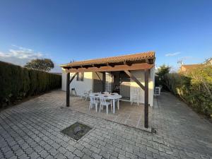 pawilon ze stołem i krzesłami na patio w obiekcie Maison avec Cour, Piscine Sécurisée, Climatisation, 3 Chambres, Proche Plage, 8 Personnes - FR-1-701-33 w mieście Vendres