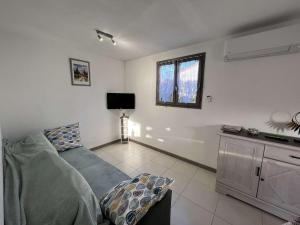salon z kanapą i telewizorem w obiekcie Maison avec Cour, Piscine Sécurisée, Climatisation, 3 Chambres, Proche Plage, 8 Personnes - FR-1-701-33 w mieście Vendres