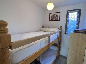 sypialnia z dwoma łóżkami piętrowymi i oknem w obiekcie Maison avec Cour, Piscine Sécurisée, Climatisation, 3 Chambres, Proche Plage, 8 Personnes - FR-1-701-33 w mieście Vendres