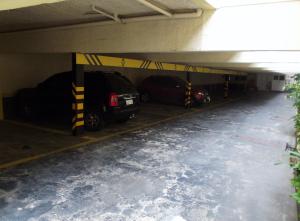 a parking garage with two cars parked in it at Charlott Hotel in Sao Paulo