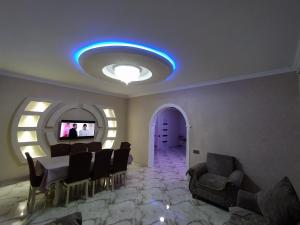 uma sala de estar com uma mesa e cadeiras e uma televisão em Guest house in Qabala em Gabala