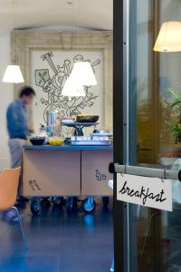 a table in a kitchen with a person in the background at Hotel Piazza Bellini & Apartments in Naples